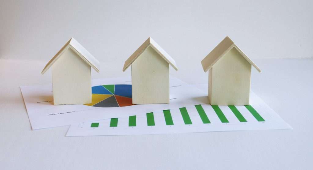 Model homes positioned over real estate data charts